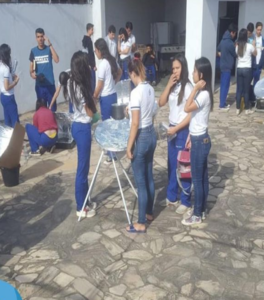 Alunos ao ar livre fazendo um forno solar.